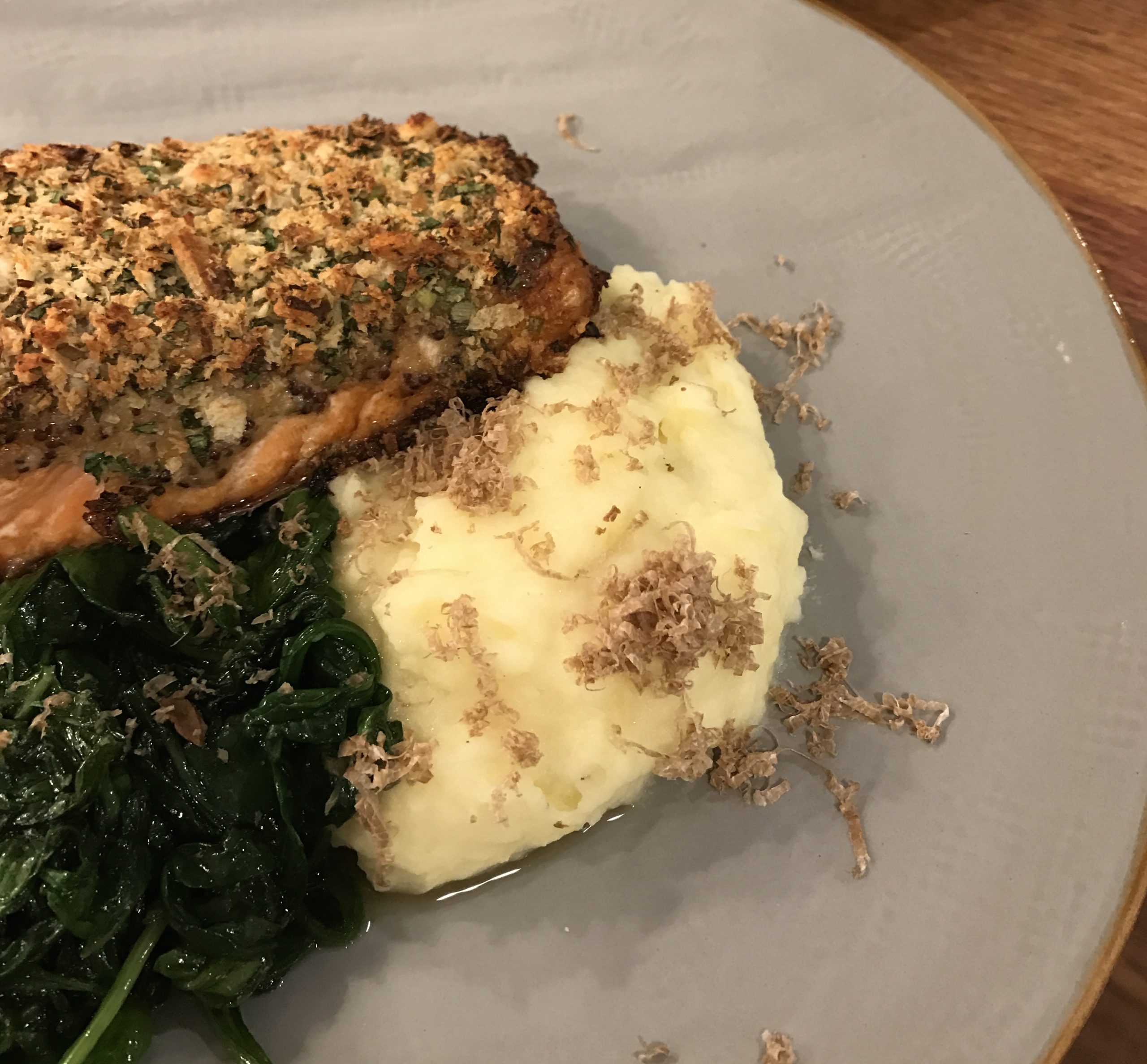 A wholesome, healthy plate bounding with nutrients in its horseradish crusted salmon, mashed potatoes, and spinach.